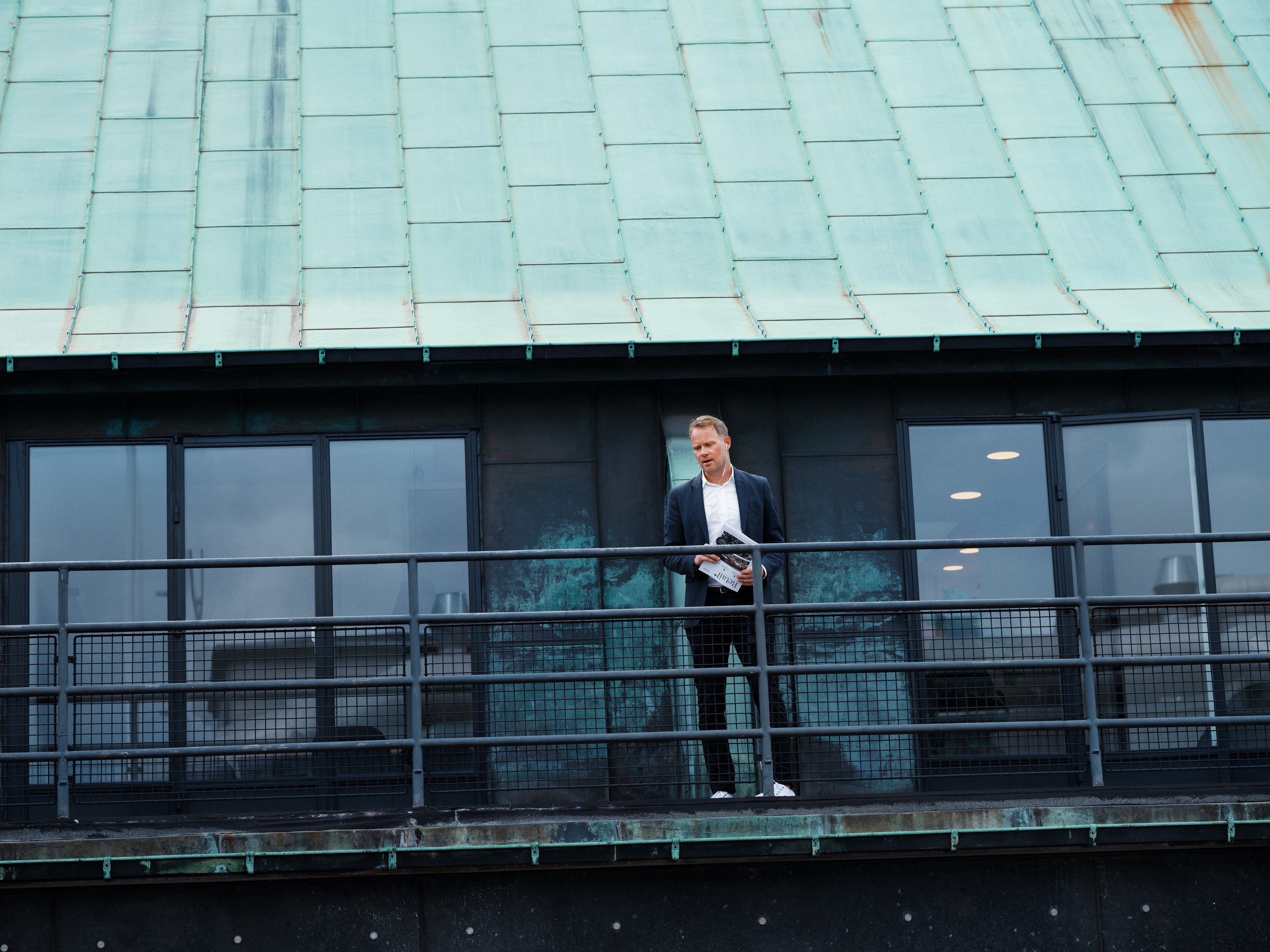 Pensionsrådgiver står på en altan og kigger ud over byen